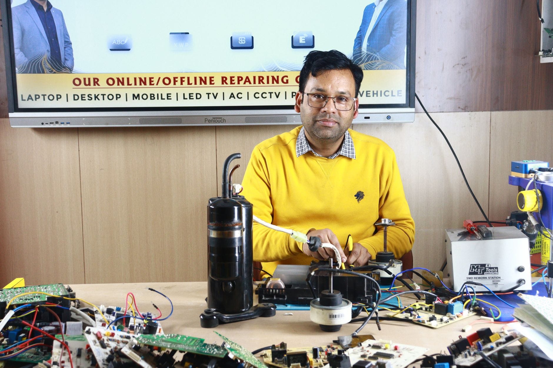 Mężczyzna naprawia klimatyzator w centrum szkoleniowym w New Delhi