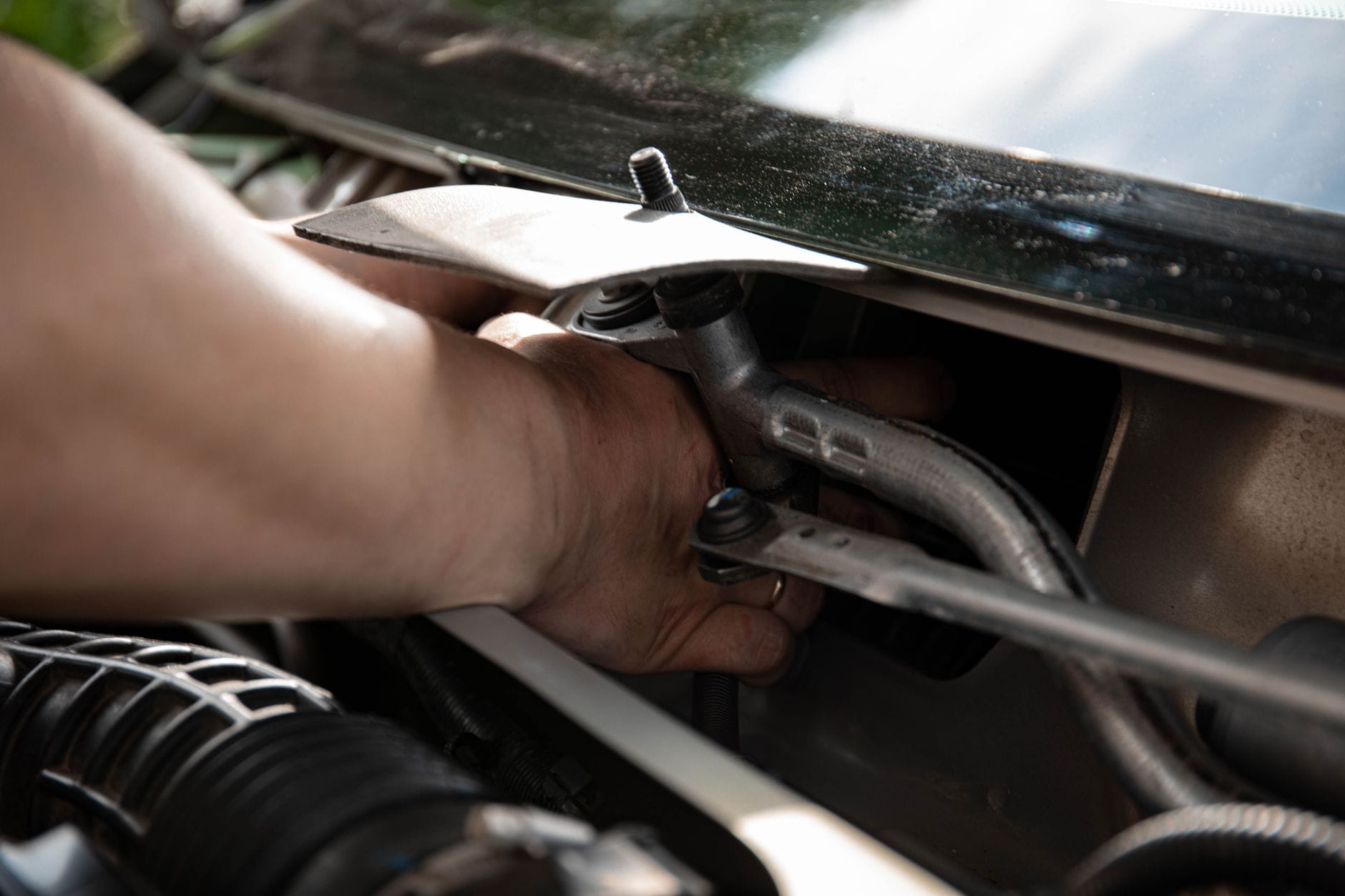 Ręce mechanika przy pracy przy instalacji elektrycznej w komorze silnika