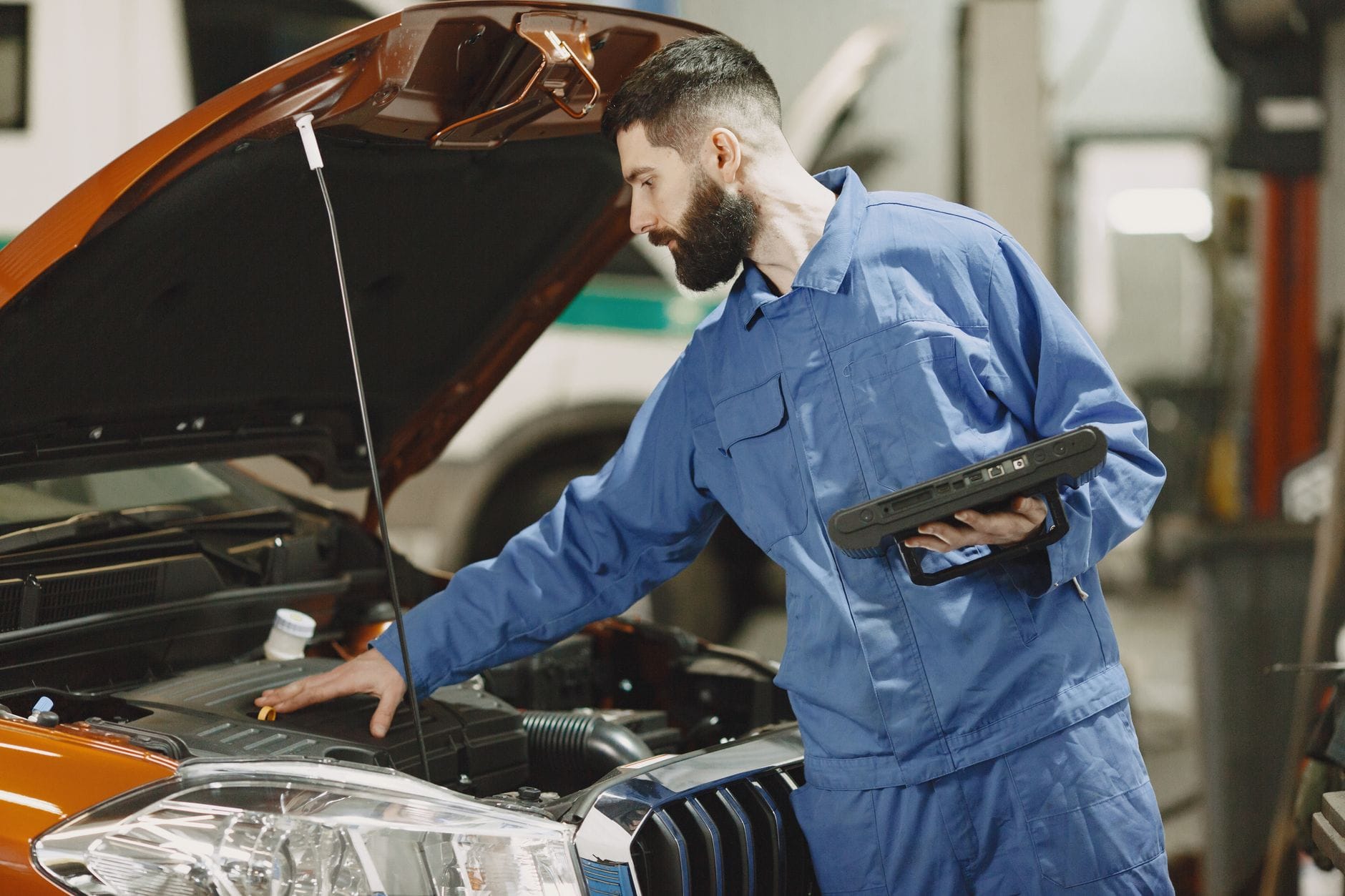 Mechanik w warsztacie sprawdza silnik samochodu przy otwartej masce