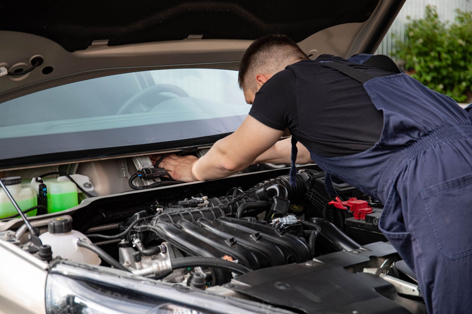 Mechanik wykonuje przegląd turbodoładowanego silnika samochodu